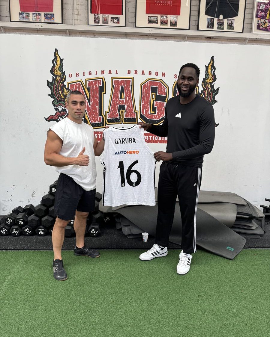 Usman Garuba y un entrenador de Naga con su camiseta firmada del Real Madrid, dorsal 16