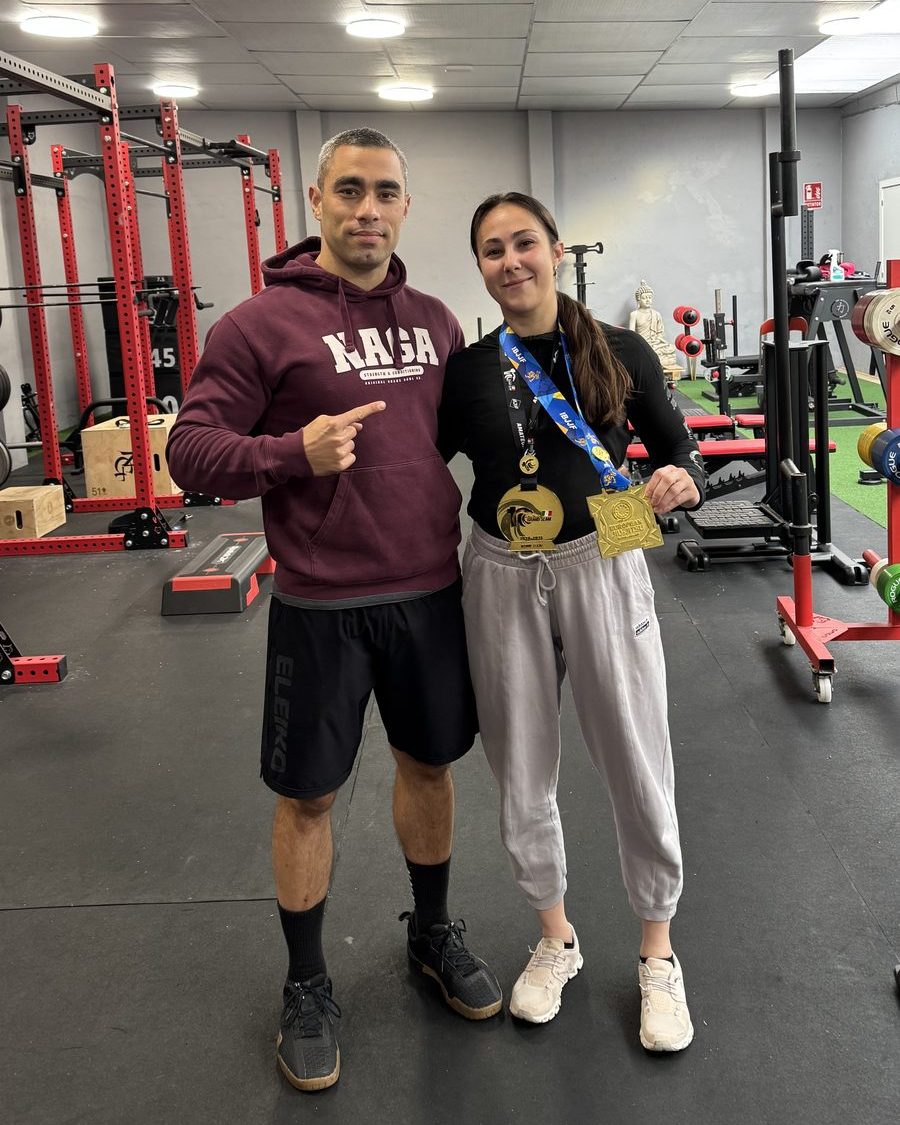 Campeona de jiu-jitsu con sus dos medallas de oro, junto a un entrenador de Naga