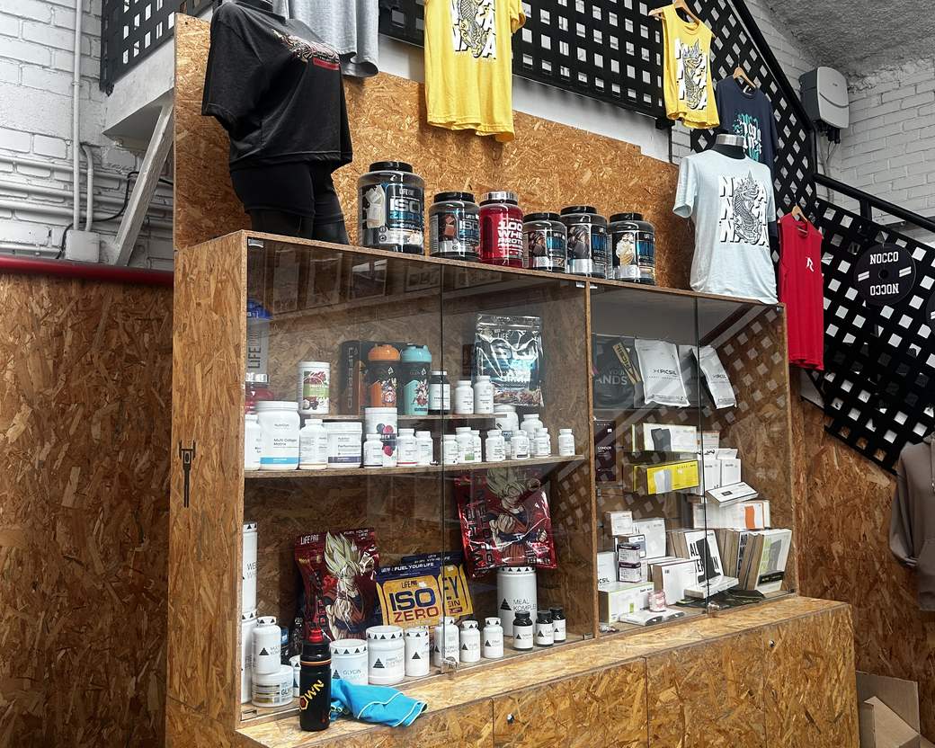 La vitrina de suplementos y la ropa de Naga en la recepción del box
