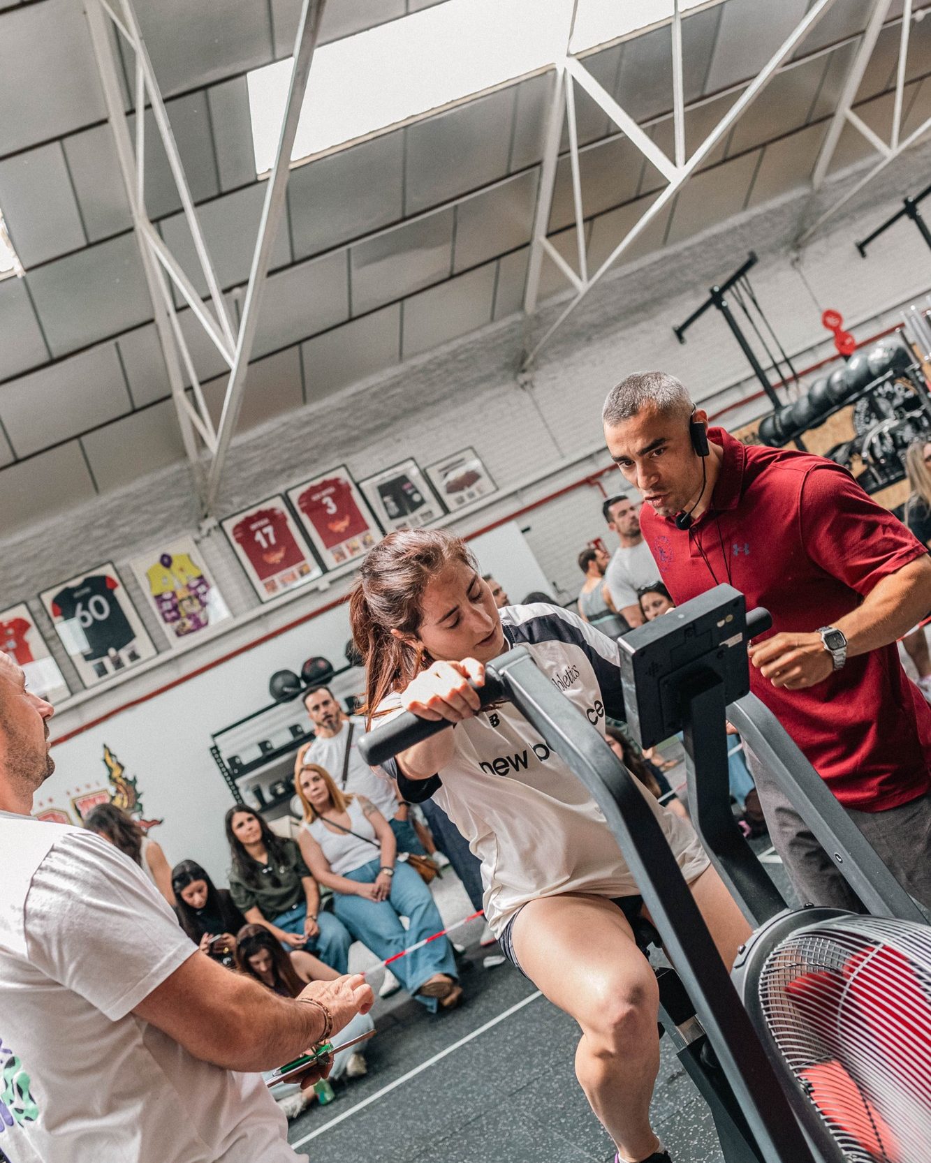 Aarón corrigiendo a una alumna en el AirBike durante una clase en Naga, con el grupo alrededor